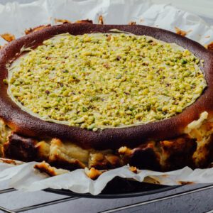 Pistachio baked cheesecake with chopped pistachio topped and pistachio spread at the top of cheesecake