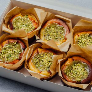 6 Pistachio homemade minicheesecakes topped with pistachio spread and chopped pistachio in a box