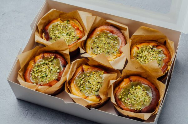 6 Pistachio homemade minicheesecakes topped with pistachio spread and chopped pistachio in a box